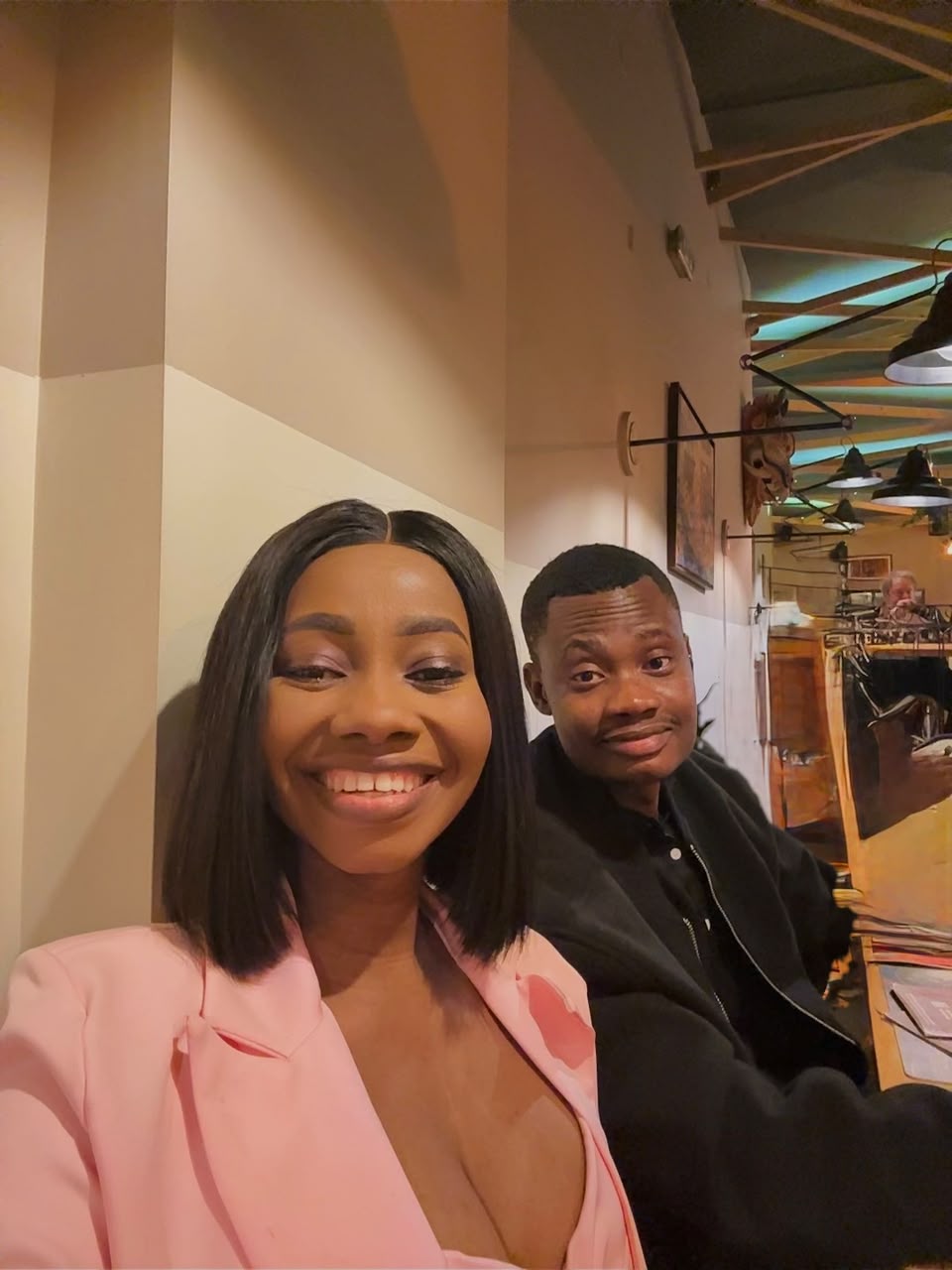 Oluwasefunmi and Olanrewaju smiling together at a restaurant