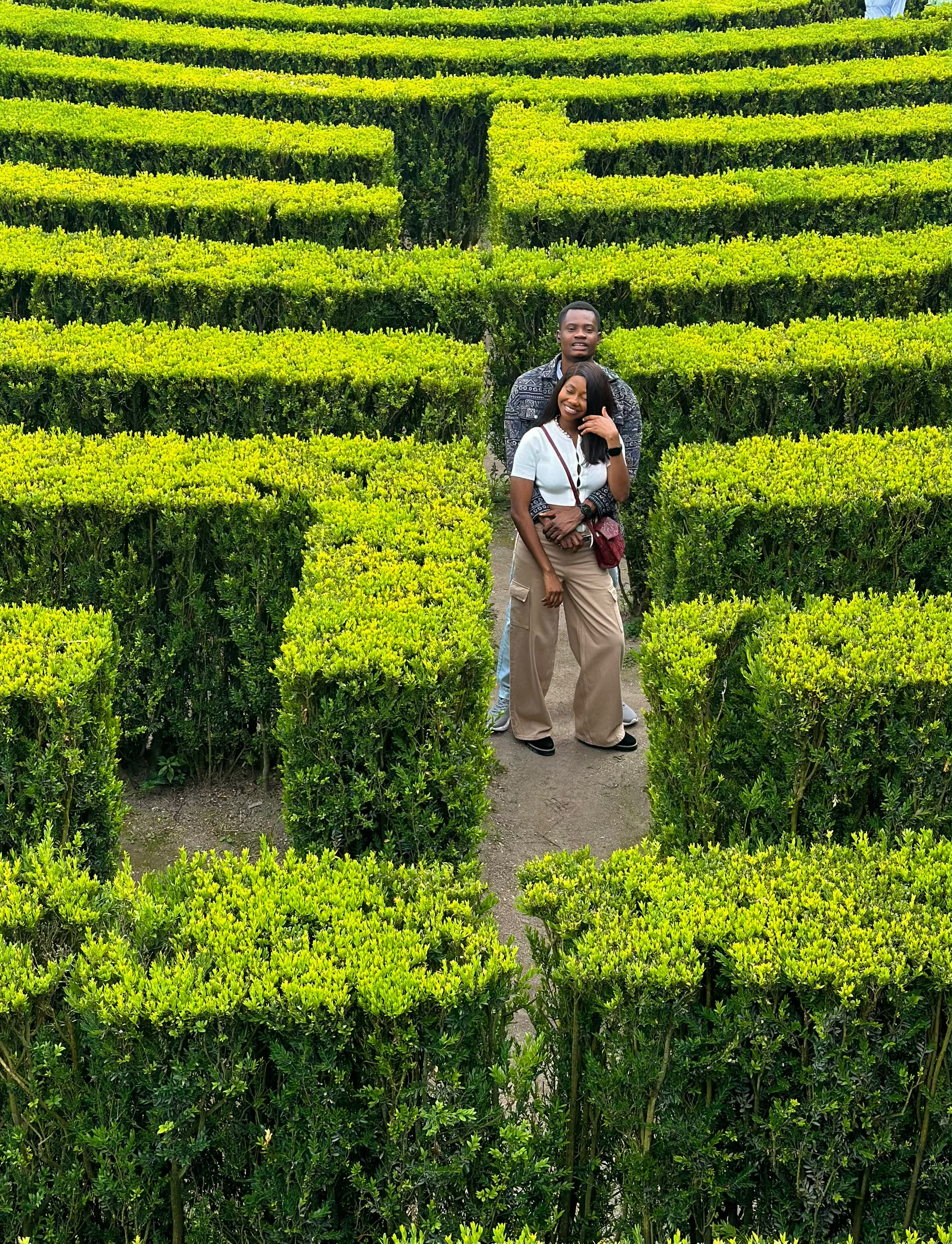 Oluwasefunmi and Olanrewaju standing together in a green garden maze