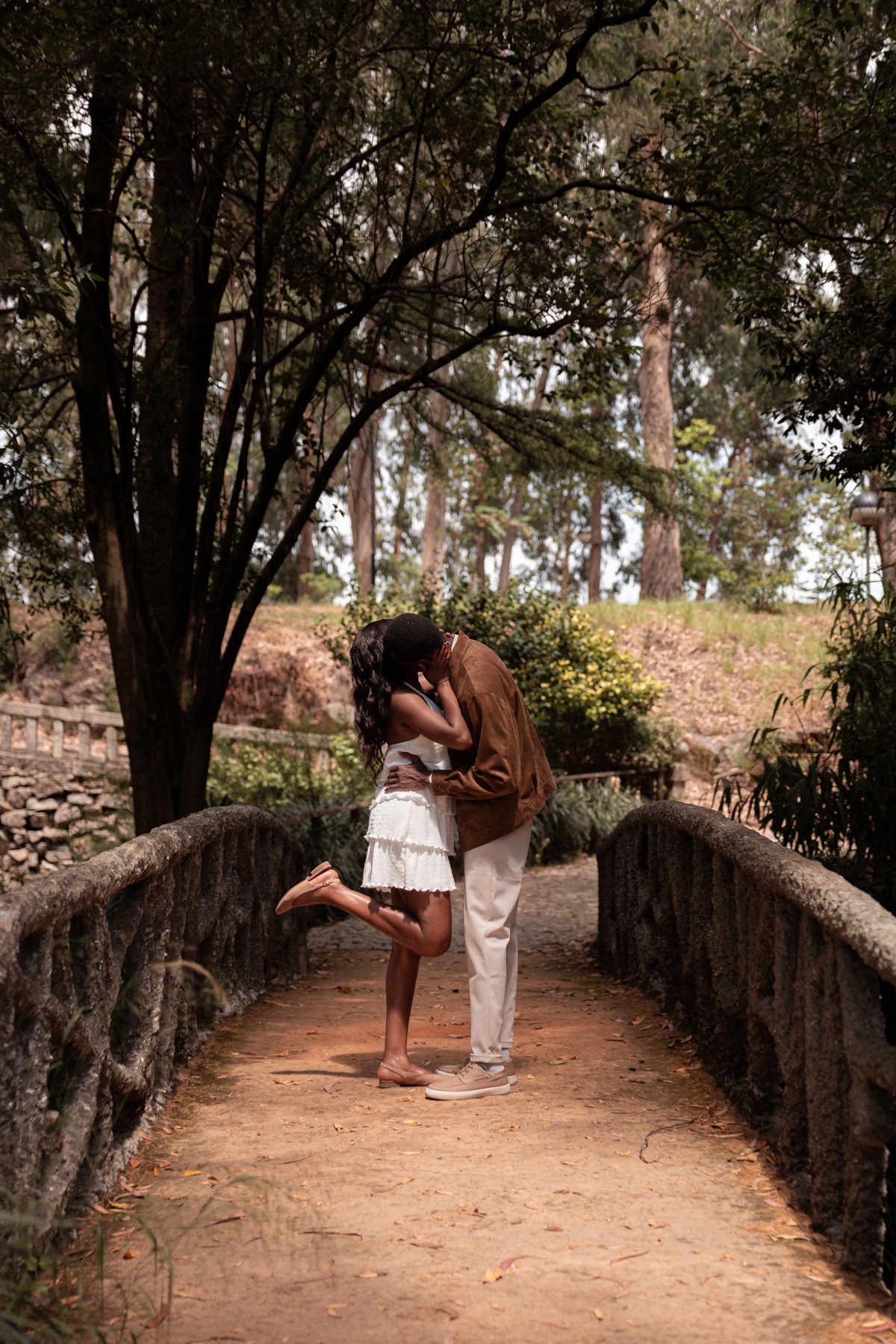 Oluwasefunmi and Olanrewaju sharing a kiss on a garden bridge