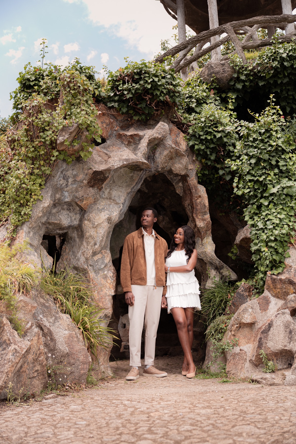 Oluwasefunmi and Olanrewaju standing together by a rocky garden cave